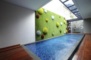 万隆达格特库安卡萨14号旅馆的一个带岩石墙的房间的游泳池