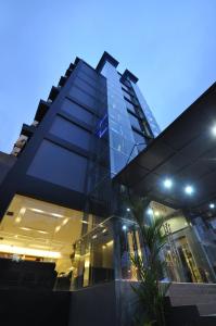 雅加达雅加达梦幻酒店的一座在晚上拥有玻璃幕墙的大建筑