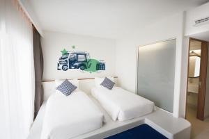 芭东海滩卢巴普吉岛芭东旅舍的卧室配有两张床和墙上的一张卡车贴纸