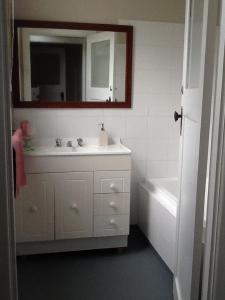 Snake ValleyRoyal Hotel Snake Valley的浴室配有盥洗盆、镜子和浴缸