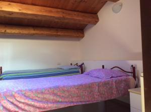 费尔特雷Il mondo roverso的一间带一张床的卧室,位于带木制天花板的房间内