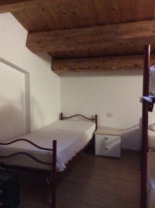 费尔特雷Il mondo roverso的一间卧室设有两张床和木制天花板