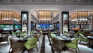 呼和浩特呼和浩特富力万达文华酒店的一间带桌椅的餐厅和一间酒吧
