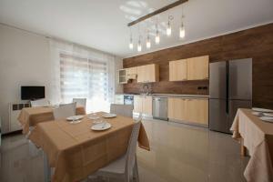 佩斯基耶拉德加达B&B Holidays Artisti的厨房以及带桌子和冰箱的用餐室