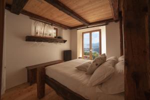 梅尔戈佐Magica Vercio的一间卧室设有一张大床和大窗户