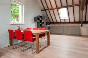 OudewaterRuyge Weyde Logies, Eco Farm的厨房配有木桌和红色椅子