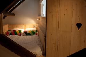 OudewaterRuyge Weyde Logies, Eco Farm的卧室配有木墙内的一张床