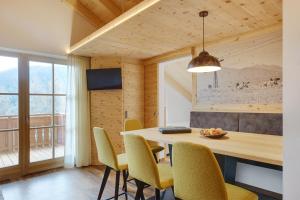 瓦尔道拉Apartments Oberpichlhof的一间带木桌和椅子的用餐室