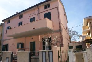 切齐纳码头Giacomo Home的一座粉红色的建筑,上面设有一个阳台