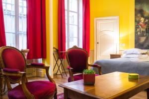 第戎Appartement Le Buffon的配有床、椅子和桌子的房间