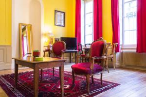 第戎Appartement Le Buffon的一间设有红色椅子、一张桌子和镜子的房间