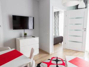 米兹多洛杰Apartament Międzyzdroje Horyzont的白色的客房设有桌子和墙上的电视