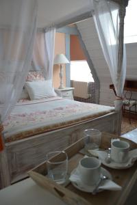 Cléres玛艾特农庄酒店的一间卧室配有一张床,包括一个杯子和玻璃杯托盘