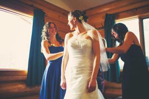 雷夫尔斯托克冰屋度假酒店的两个女人在新娘的婚纱上帮她