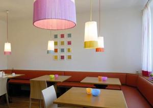 慕尼黑提契诺商业&经济型酒店的餐厅配有桌椅和吊灯