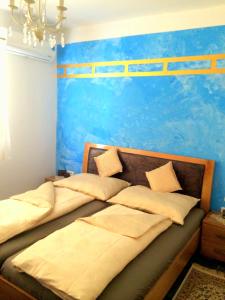 马赫迪耶Apart Mahdia的卧室设有两张床铺,拥有蓝色的墙壁