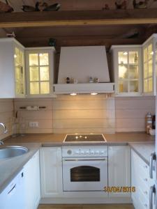 弗济内Apartments Montana的厨房配有白色橱柜和炉灶烤箱。