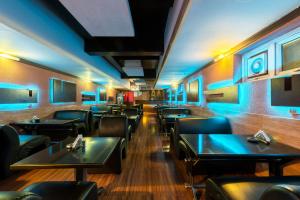 哥印拜陀Treebo Trend ESS Grande的一间设有黑色桌椅和蓝色灯光的餐厅