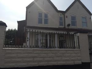 伯明翰Vicarage Lodge Birmingham的白色的房子,有黑色的围栏