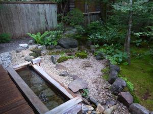 高山木下住宿加早餐旅馆的一座花园,花园内设有水和岩石池