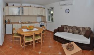 蒂瓦特Apartments Miana的厨房以及带桌子和沙发的客厅。