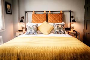 泰晤士河畔金斯顿昆世海德酒店的卧室配有一张带黄色床单和枕头的大床。