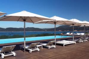 特罗亚特罗亚设计酒店的游泳池旁的一排椅子和遮阳伞