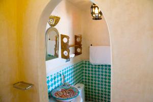 丹吉尔古堡玫瑰旅馆的一间带卫生间、水槽和镜子的浴室