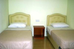 瓜拉丁加奴十星酒店的两张睡床彼此相邻,位于一个房间里