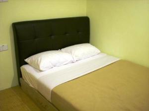 瓜拉丁加奴十星酒店的一张带黑色床头板和两个白色枕头的床