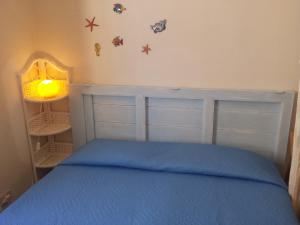 马里迪莫Cortile Via San Simone Marettimo的一间卧室配有一张带蓝色床罩的床