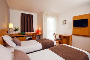 拉罗谢尔罗谢尔米尼姆公园和套房酒店的酒店客房配有两张床和一张书桌