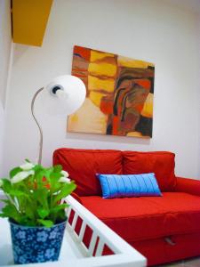 锡拉库扎福斯托公寓的客厅里红色的长沙发,长着植物