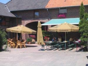 克分楞麦穆勒尔酿酒厂旅馆的一个带遮阳伞和桌椅的庭院和一座建筑