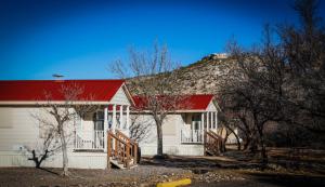 卡顿伍德Verde Valley One-Bedroom Park Model Cabin 13的白色的房子,有红色的屋顶和山