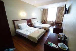 巴统Hotel 725的酒店客房设有两张床和一张桌子。