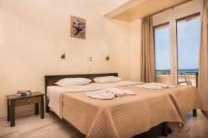 马莱迈神话海滩酒店公寓的一间卧室配有一张床,上面有两条毛巾