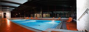 米滕瓦尔德博斯特酒店的大楼内带椅子的大型游泳池