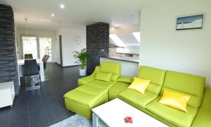 Besedice斯卡洛公寓的一间带绿色沙发的客厅和一间厨房