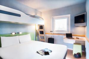 克莱蒙费朗Ibis Budget Clermont Ferrand - Le Brezet - Aeroport的一间卧室配有一张床和一张双层床。