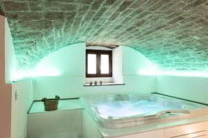 卡纳拉Albergo Il Rientro的带浴缸的浴室,拥有砖砌天花板