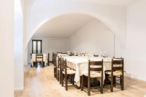 卡纳拉Albergo Il Rientro的一间配备有白色桌椅的用餐室