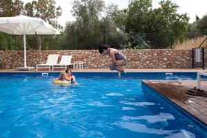罗什平纳帕奈别墅的一名女子和一个孩子跳入游泳池