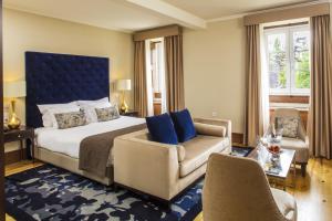 科英布拉眼泪庄园酒店 - 小型豪华酒店的一间卧室配有一张床、一张沙发和一把椅子