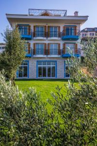 瑟阿哲克Clementin Suits Sigacık的公寓大楼位于草坪上,设有阳台。