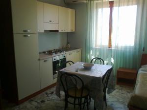 布林迪西阿普罗多酒店的一间带桌椅的厨房和一间带炉灶的厨房