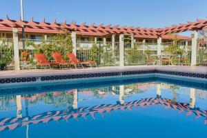 摩押摩押中心华美达酒店的一座配有桌椅的酒店游泳池