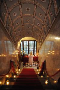 威尼斯大运河皮萨尼宫酒店的一位女士走下铺有红色地毯的楼梯