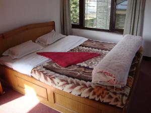 博卡拉新峰会宾馆的一张带两个枕头的床和床罩