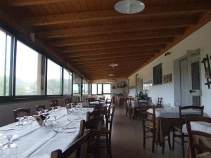 奥列纳Agriturismo Locoe的用餐室设有桌椅和窗户。